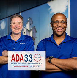 Photo of two men, both with their arms crossed, smiling and standing in front of hallway art. A logo appears over the photo, reading: "ADA33, 1990 - 2023. Americans with Disabilities Act - Celebrate the ADA! July 26, 2023"