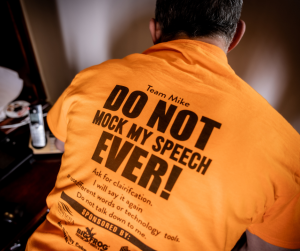 Photo of the back of Michael's orange t-shirt. Text on shirt reads "Do not mock my speech ever!" 