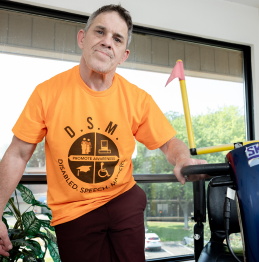Photo of Michael, a client at Lifeworks, wearing an orange "Disabled Speech Matters" t-shirt that he designed.